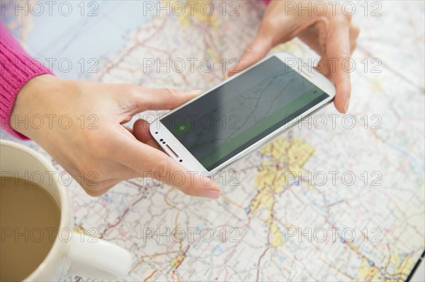 Mixed race woman taking cell phone photograph of roadmap