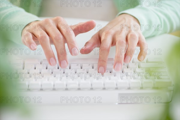 Mixed race woman typing on computer keyboard
