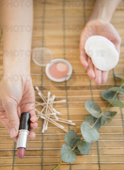 High angle view of mixed race woman holding makeup