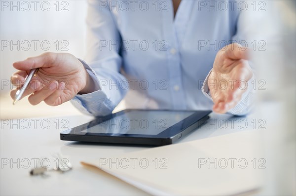 Mixed race businesswoman using digital tablet at desk