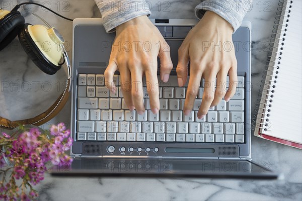 Mixed race woman using laptop at table