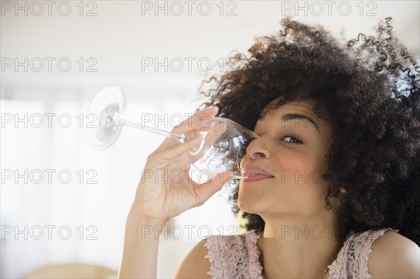 Mixed race woman drinking glass of wine