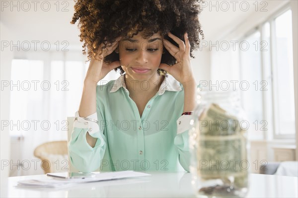 Stressed mixed race woman paying bills