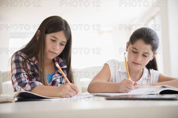 Caucasian twin sisters doing homework