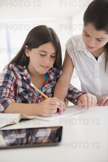 Caucasian twin sisters doing homework