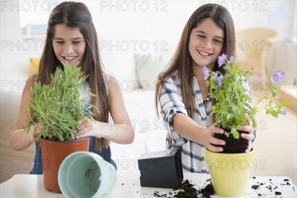 Caucasian twin sisters planting flowers