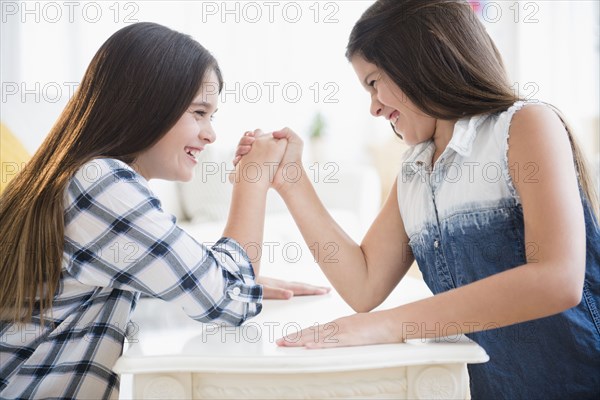 Caucasian twin sisters arm wrestling
