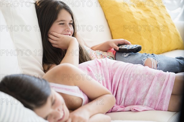 Caucasian twin sisters watching television