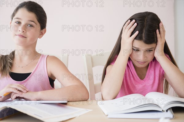 Caucasian twin sisters doing homework