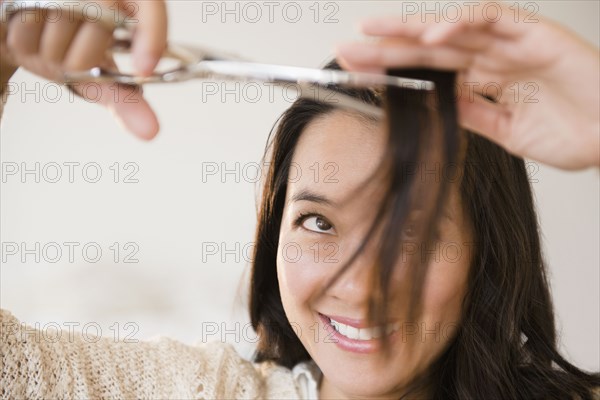 Chinese woman cutting her bangs