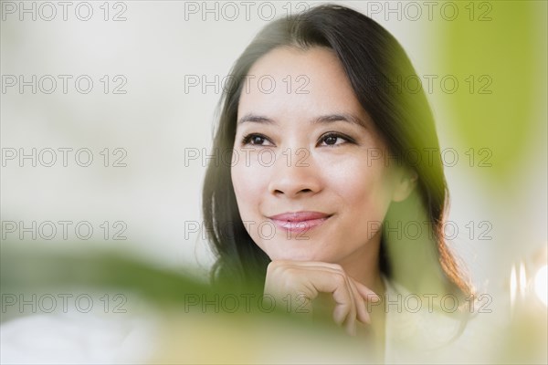 Chinese woman smiling with chin in hand