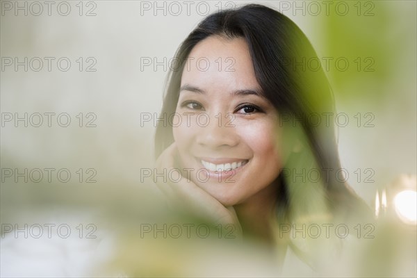 Chinese woman smiling with chin in hand