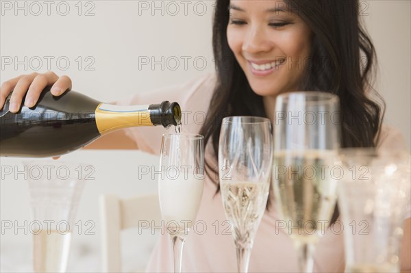 Chinese woman pouring champagne