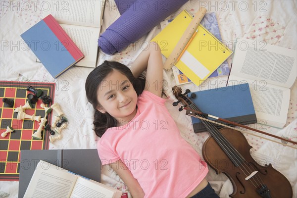 Girl laying on floor with hobbies and homework