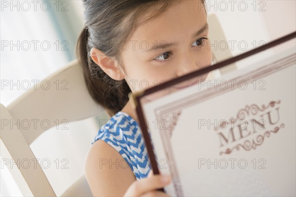 Girl reading menu in restaurant