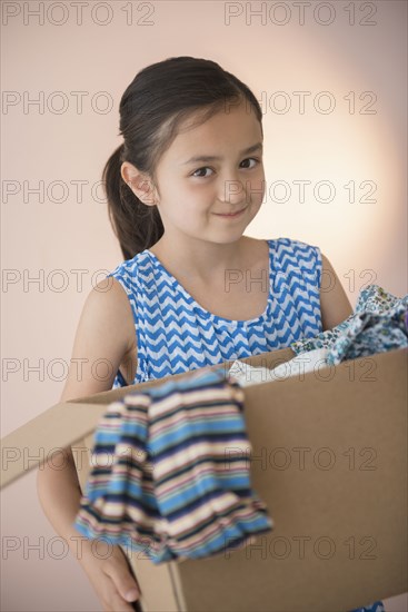 Girl holding box of clothing for donation