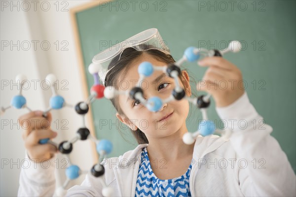 Girl examining molecular model in science class