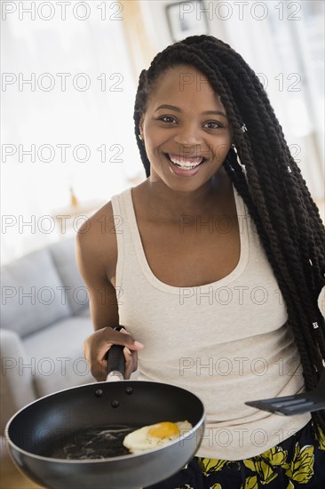 Black woman cooking egg