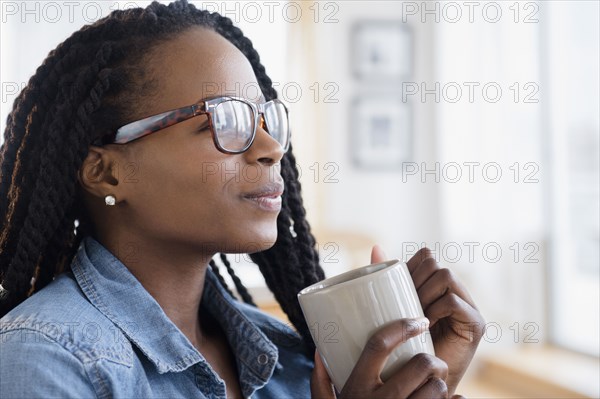 Black woman drinking cup of coffee