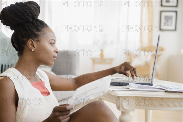 Black woman paying bills on laptop