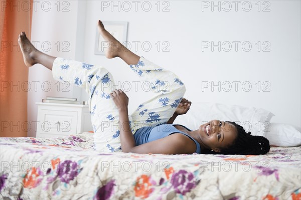 Black woman playing on bed