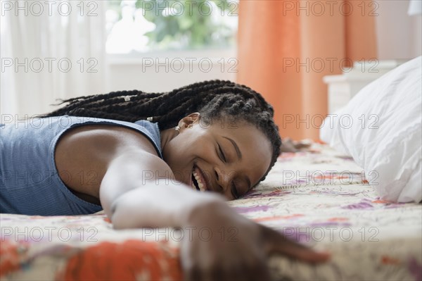 Black woman laying on bed