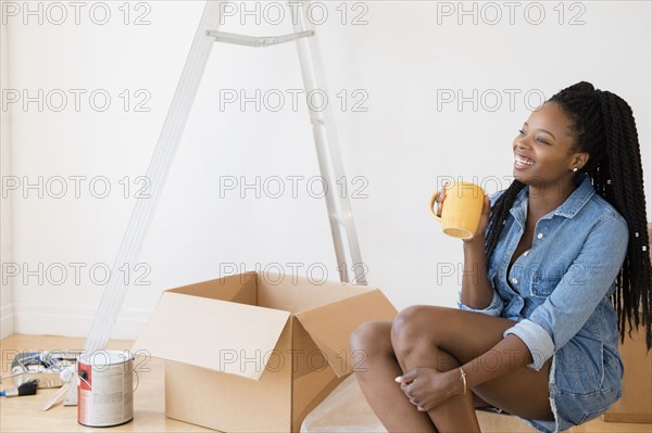 Black woman drinking coffee in new home