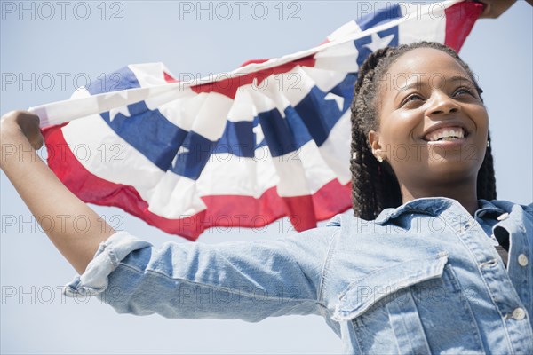 Black woman carrying American flag banner