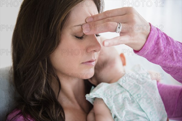 Stressed mother pinching her forehead