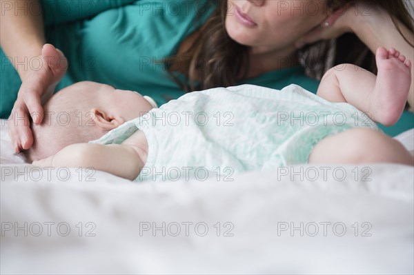 Mother playing with baby daughter