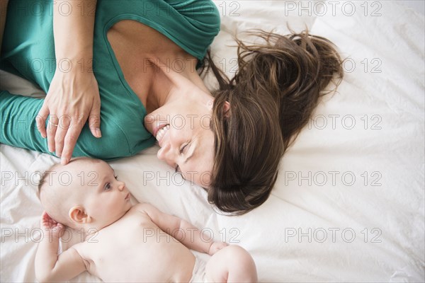 Mother laying with baby daughter