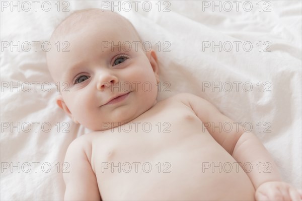 Caucasian baby girl laying on bed