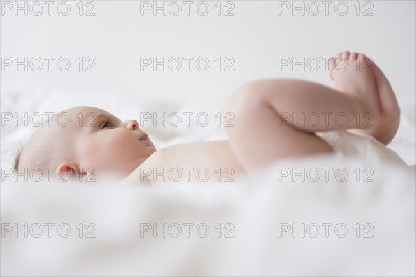 Caucasian baby girl laying on bed