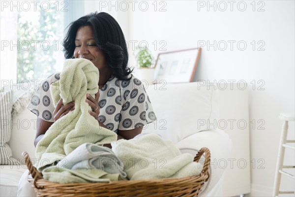 Black woman smelling clean laundry