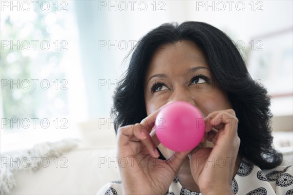 Black woman inflating balloon