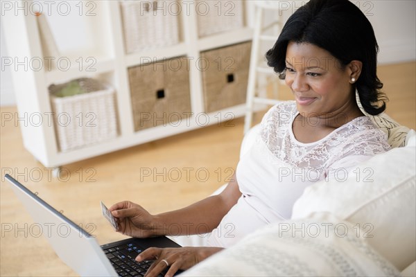 Black woman paying bills on laptop