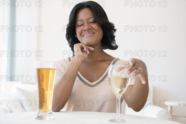 Black woman choosing between white wine and beer