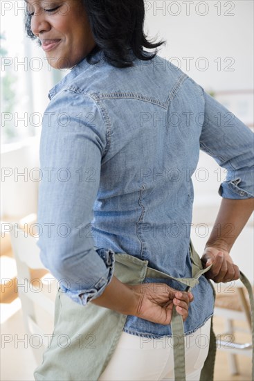 Black woman tying apron around waist