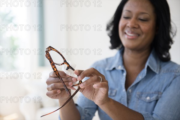 Black woman cleaning eyeglasses