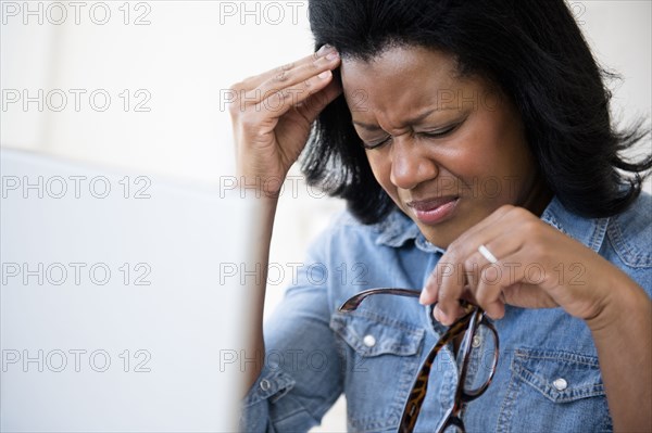 Frustrated Black woman rubbing her forehead