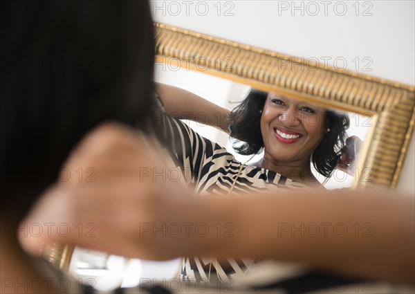 Black woman admiring herself in mirror