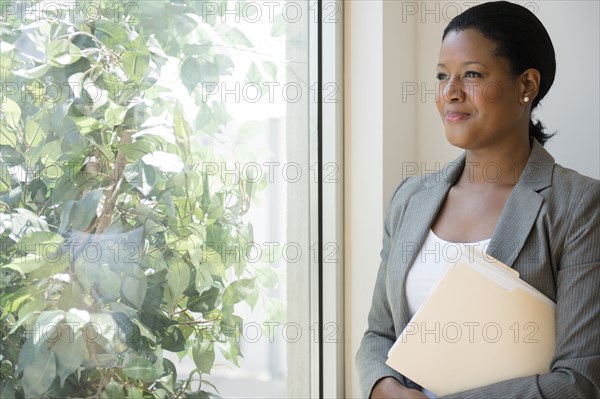Black businesswoman looking out window