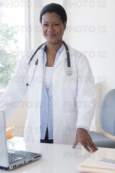 Black doctor standing at desk