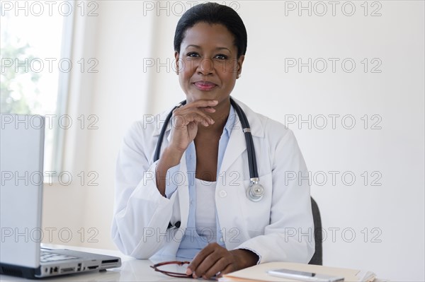 Black doctor sitting at desk