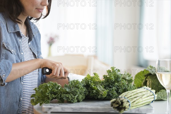 Hispanic woman chopping salad greens