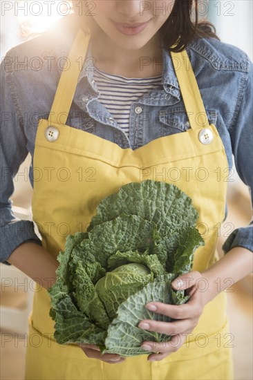 Hispanic woman holding head of lettuce