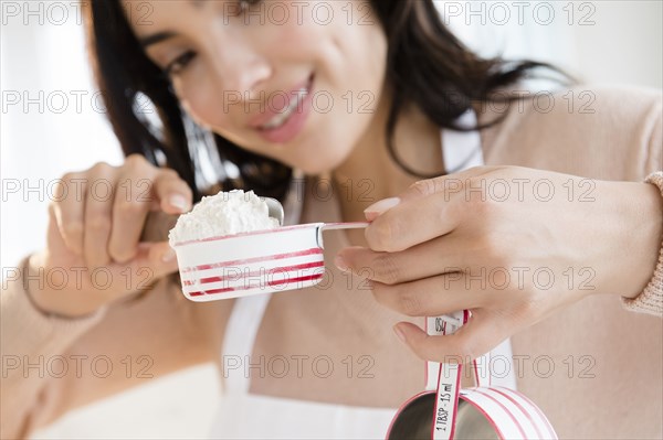 Hispanic woman measuring flour