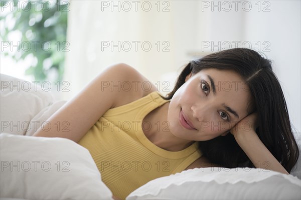 Hispanic woman laying in bed