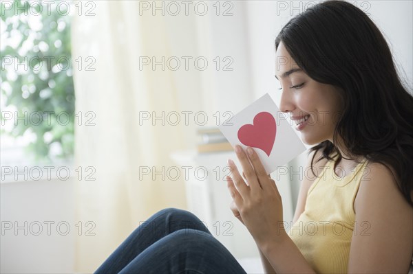 Hispanic woman reading romantic card