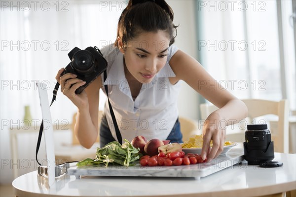 Hispanic woman photographing food